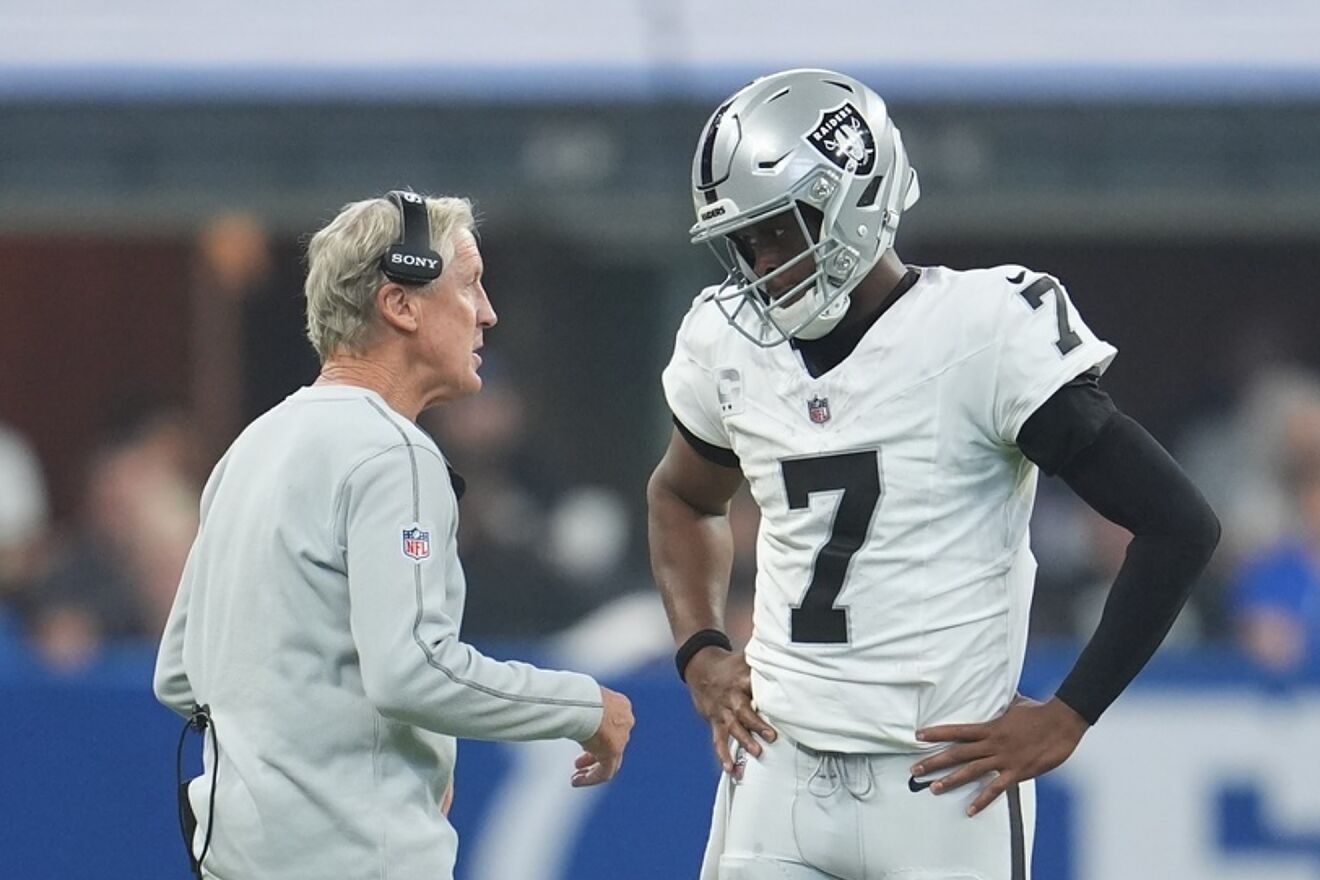 Las Vegas Raiders head coach Pete Carroll talks with quarterback Geno...